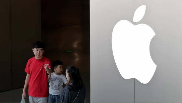 Una familia china sale de una tienda de Apple en Beijing