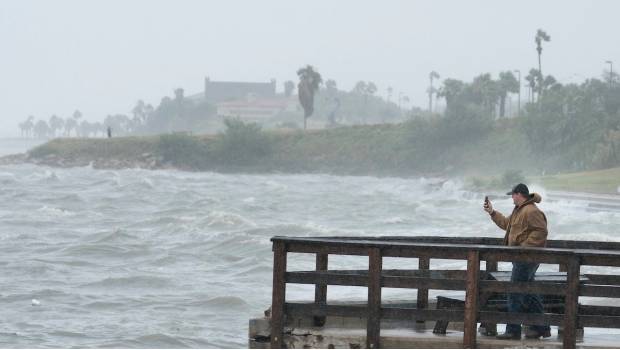 Un habitante de Cole Park toma una fotografía del mar a unas horas de la llegada de Harvey