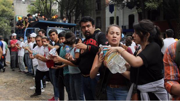 Voluntarios cargan víveres para los damnificados por el sismo del 19 de septiembre.