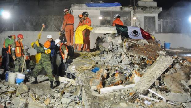 Una bandera mexicana sobre los trabajos de rescate en edificio derrumbado en la Ciudad de México. 