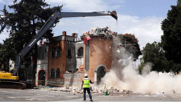 Una grúa demuele un edificio dañado por el sismo del 19 de septiembre en Puebla. 