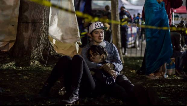 Dos voluntarios descansan tras ayudar por horas en labores de rescate tras el sismo del 19 de septiembre.