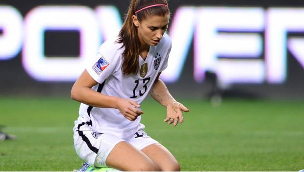 Alex Morgan genuflexa en el césped.